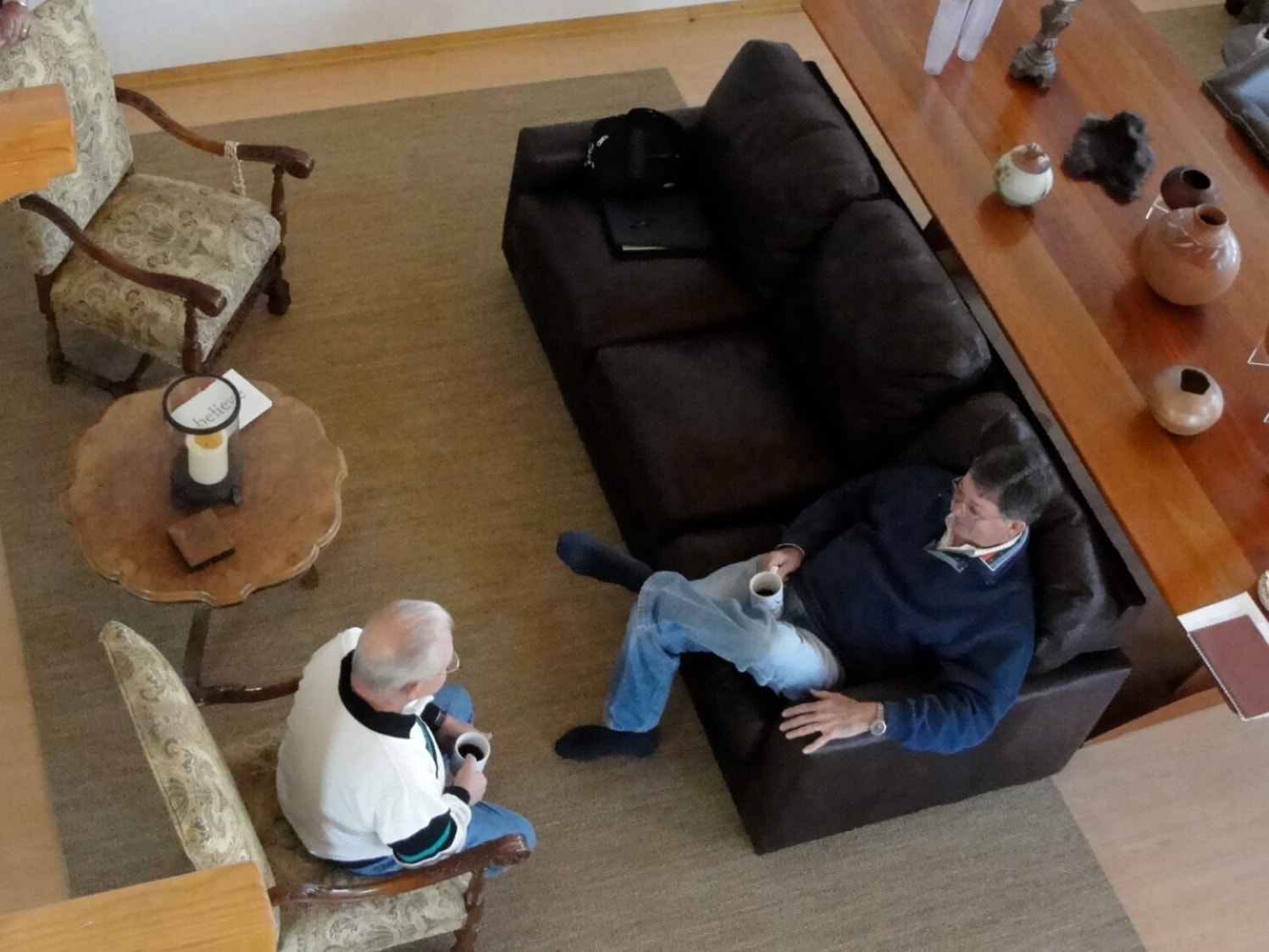 Birds-eye view of men chatting with coffee