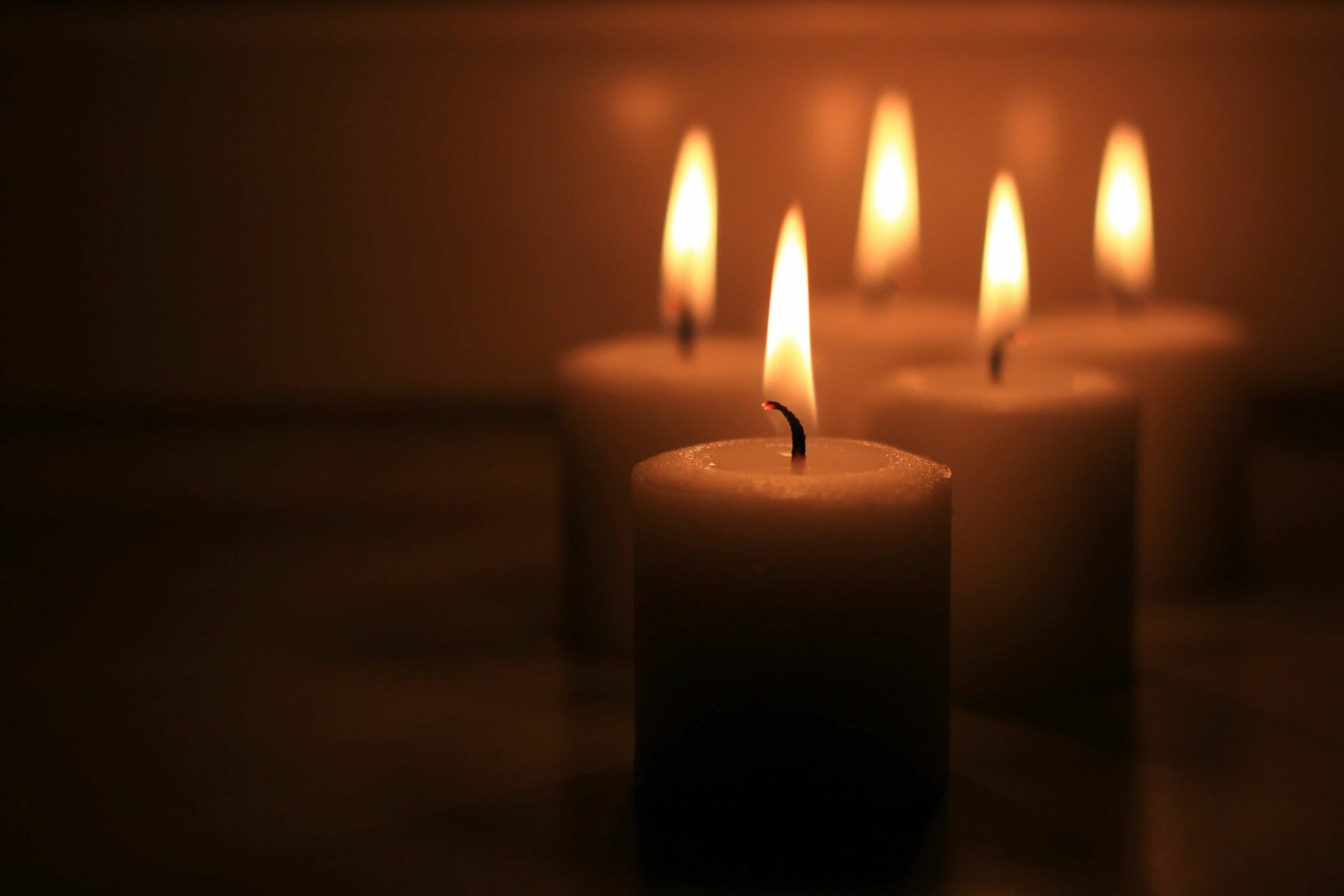 Lit candles glowing softly in dark