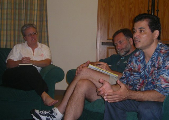 Three adults sitting and talking in living room