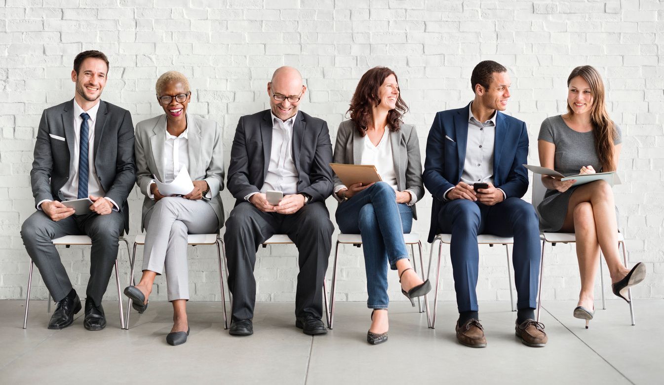 Six professionals seated waiting for job interviews